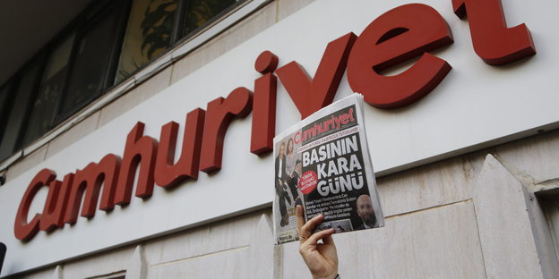 Vor dem Redaktionsgebäude von Cumhuriyet wird eine Ausgabe der Zeitung hochgehalten.