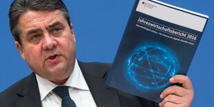 Sigmar Gabriel hält seinen Jahreswirtschaftsbericht in die Höhe.