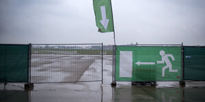 Absperrung auf dem Tempelhofer Feld - mit Hinweisen zum Durchlass. Es regnet.