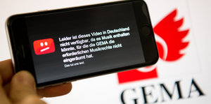 Auf einem Smartphone ist der Hinweis des Video-Portals YouTube zu sehen, nach dem ein Video wegen fehlender Musikrechte der GEMA in Deutschland nicht gezeigt werden darf.