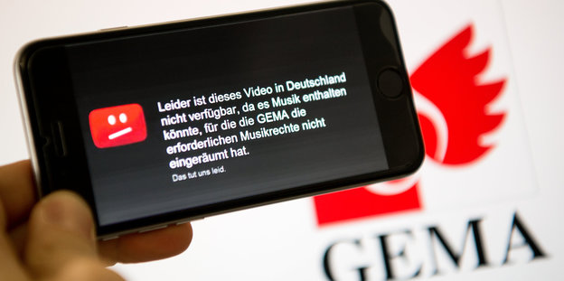 Auf einem Smartphone ist der Hinweis des Video-Portals YouTube zu sehen, nach dem ein Video wegen fehlender Musikrechte der GEMA in Deutschland nicht gezeigt werden darf.