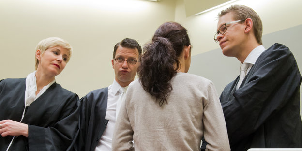 Beate Zschäpe von hinten umringt von ihren drei Anwälten im Gericht