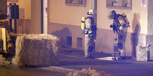 Zwei Feuerwehrmänner vor einem Haus.