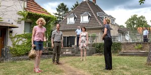 Dortmunder Kommissare stehen mit drei anderen in einem Garten vor einem Haus