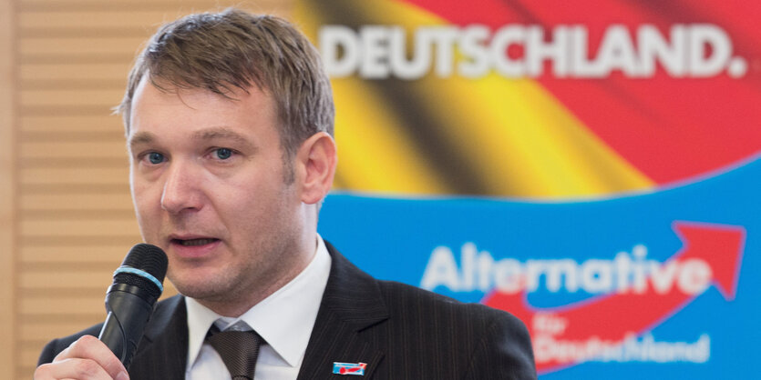 André Poggenburg mit Mikrofon in der Hand