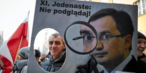 Polnische Anti-Regierungs-Demonstranten mit einem Plakat von Justizminister Zbigniew Ziobro.