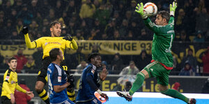 Ein Spieler von Borussia Dortmund köpft den Ball, der gegnerische Torwart streckt sich wie ein Handballtorwart, kommt aber nicht heran