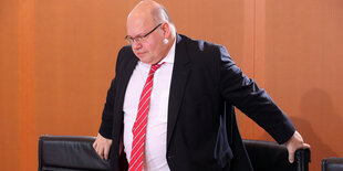 Peter Altmaier steht zwischen zwei Stühlen