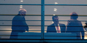 Horst Seehofer, Sigmar Gabriel und Angela Merkel sind durch das Fenster des Kanzleramtes zu sehen