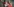 Eine strahlend lächelnde Frau mit blonden Haaren und pinker Sportjacke - es ist Angelique Kerber - vor ihr eine Frau mit Handy, hinter ihr ein Mann mit Handy, beide versuchen sich mit Kerber zu fotografieren