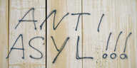 Mit Schwarzer Sprühfarbe stehen die Worte "Anti Asyl" an einer Wand