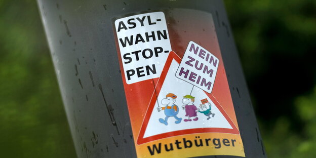 Ein Aufkleber „Asyl-Wahn Stoppen – Nein zum Heim – Wutbürger“ klebt an einem Laternenmast in unmittelbarer Nähe des Leonardo-Hotel in Freital (Sachsen).