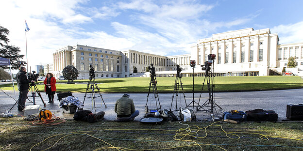 MedienvertreterInnen und Kameras auf Stativen vor dem Völkerbundpalast in Genf.