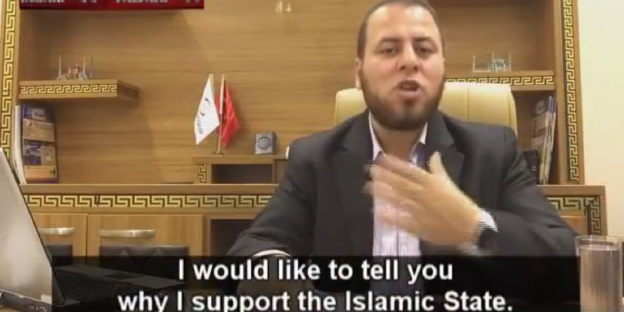 Screenshot aus dem Video: ein Mann in Anzug vor hölzernem Hintergrund. Im Untertitel ist zu lesen: „I would like to tell you why I support the Islamic State."“