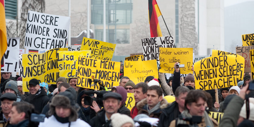 Pegida-Demonstranten mit vielen Schildern