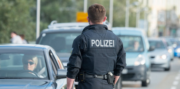 Ein Bundespolizist kontrolliert an der deutsch-österreichischen Grenze in Simbach am Inn Fahrzeuge