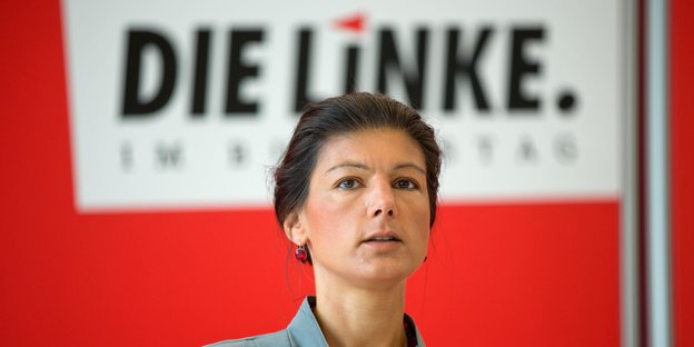 Sahra Wagenknecht steht vor einem Die-Linke-Schild.