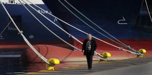 Ein Mann läuft durch den Hafen in Piräus