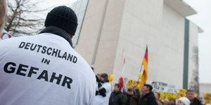 Ein Mann bei einer Demo mit dem T-Shirt-Aufdruck „Deutschland in Gefahr“
