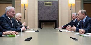 Seehofer und Putin sitzen sich an einem Tisch gegenüber, neben Seehofer sitzt Stoiber.