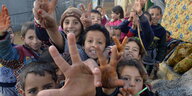 Syrische Flüchtlingskinder lachen und machen das Victory-Zeichen
