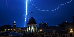 Ein Blitz schlägt an einem Gebäude in Kansas City ein. Der Himmel ist tiefblau.