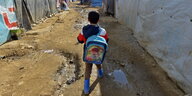 Ein syrischer Junge trägt seinen Rucksack zur Schule