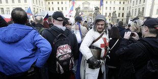 Ein als Ritter verkleideter Mann steht in einer Menschenmenge