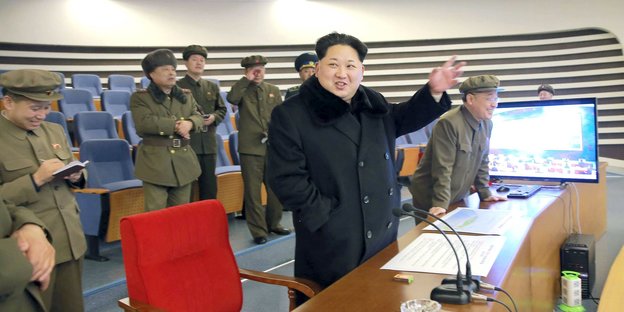Kim Jong Un und Soldaten stehen vor einem Monitor