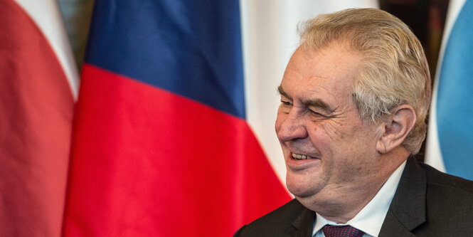 Miloš Zeman vor einer großen tschechischen Fahne.