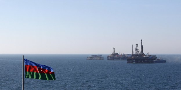 Blick auf eine Förderplattform, im Vordergund die aserbaidschanische Flagge