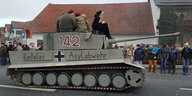 Ein Karnevals-Wagen in Gestalt eines Panzers mit der Aufschrift „Ilmtaler Asylabwehr“ fährt eine Straße entlang