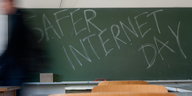 Eine grüne Schiefertafel in einem Klassenzimmer. Darauf steht mit Kreide geschrieben: "Safer Internet Day""