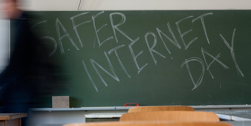 Eine grüne Schiefertafel in einem Klassenzimmer. Darauf steht mit Kreide geschrieben: "Safer Internet Day""