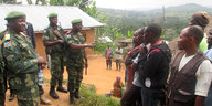 Eine Gruppe Soldaten redet mit einer Gruppe Zivilisten.