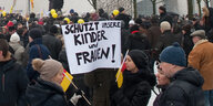 Eine Menge von Menschen steht vor dem Kanzleramt, ein Schild „Schützt unsere Kinder und Frauen“ wird hochgehalten