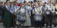 Eine Gruppe Frauen steht beieinander, eine trägt eine Trommel