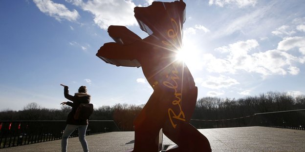 Eine Besucherin imitiiert die Haltung des Berlinale-Bären