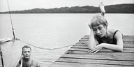 Filmstill in Schwarz-weiß mit Mann und Frau an einem See