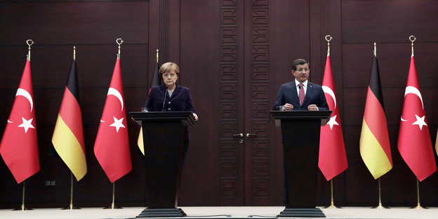 Angela Merkel, links, und Ahmet Davutoglu an Stehpulten vor deutschen und türkischen Flaggen bei der Pressekonferenz