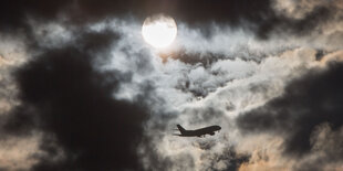 Ein Flugzeug fliegt durch den bewölkten Himmel.