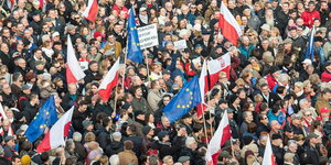 Menschenmasse mit polnischen und europäischen Flaggen