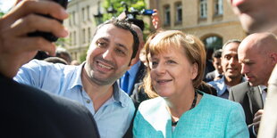 Angela Merkel lässt sich für ein Selfie mit einem Flüchtling fotografieren