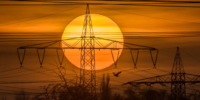 Hochspannungsmasten vor einer untergehenden Sonne