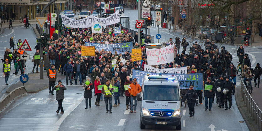 Demonstrationszug, von Polizeiwagen begleitet.