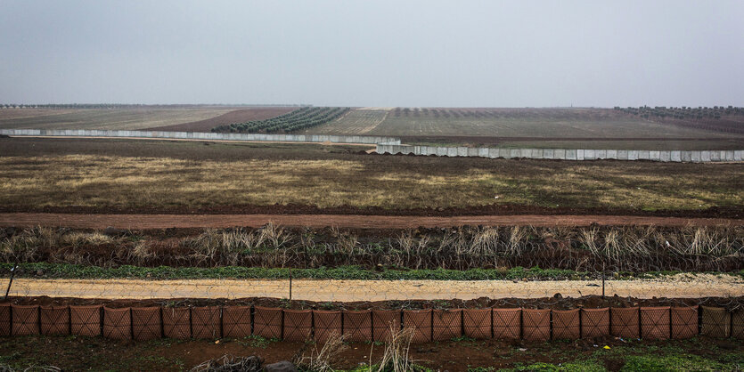 Flaches Land, durchzogen mit Zäunen und Mauern, schlechtes Wetter.