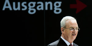 Ex-VW-Vorstnandschef Winterkorn steht vor einem schwarzen Hintergrunf mit dem Schriftzug "Ausgang".