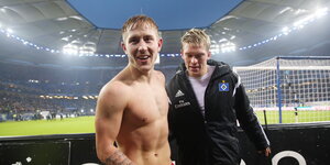 zwei Fußballer bei Flutlicht im HSV-Stadion, einer ohne Trikot